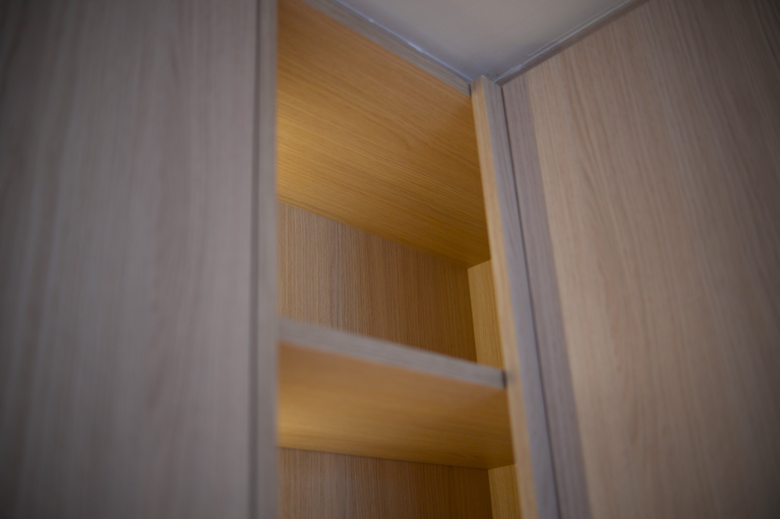 Bespoke oak wardrobe joinery with LED-lit open shelving