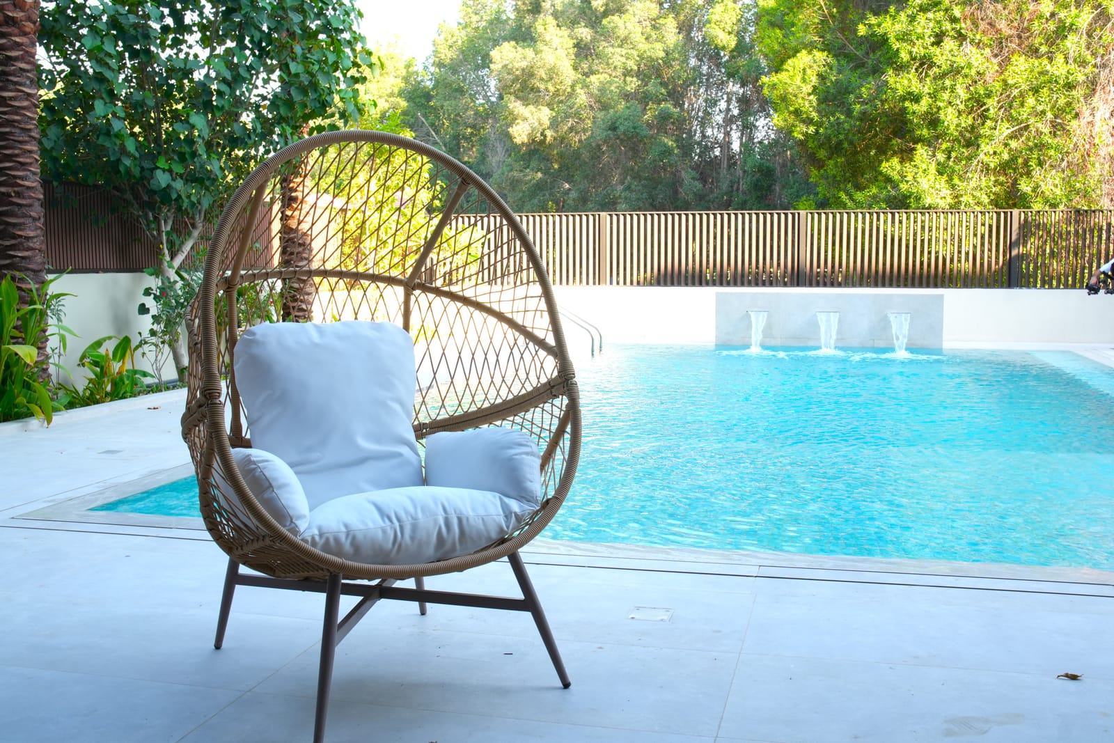 Swimming pool with water features and mature planting in a Meydan villa garden