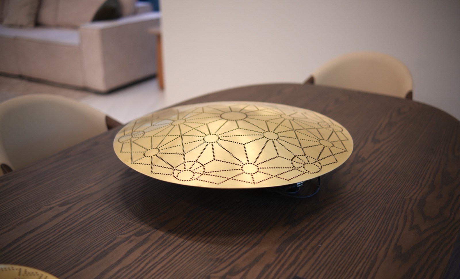 Brass geometric centrepiece on a solid oak dining table
