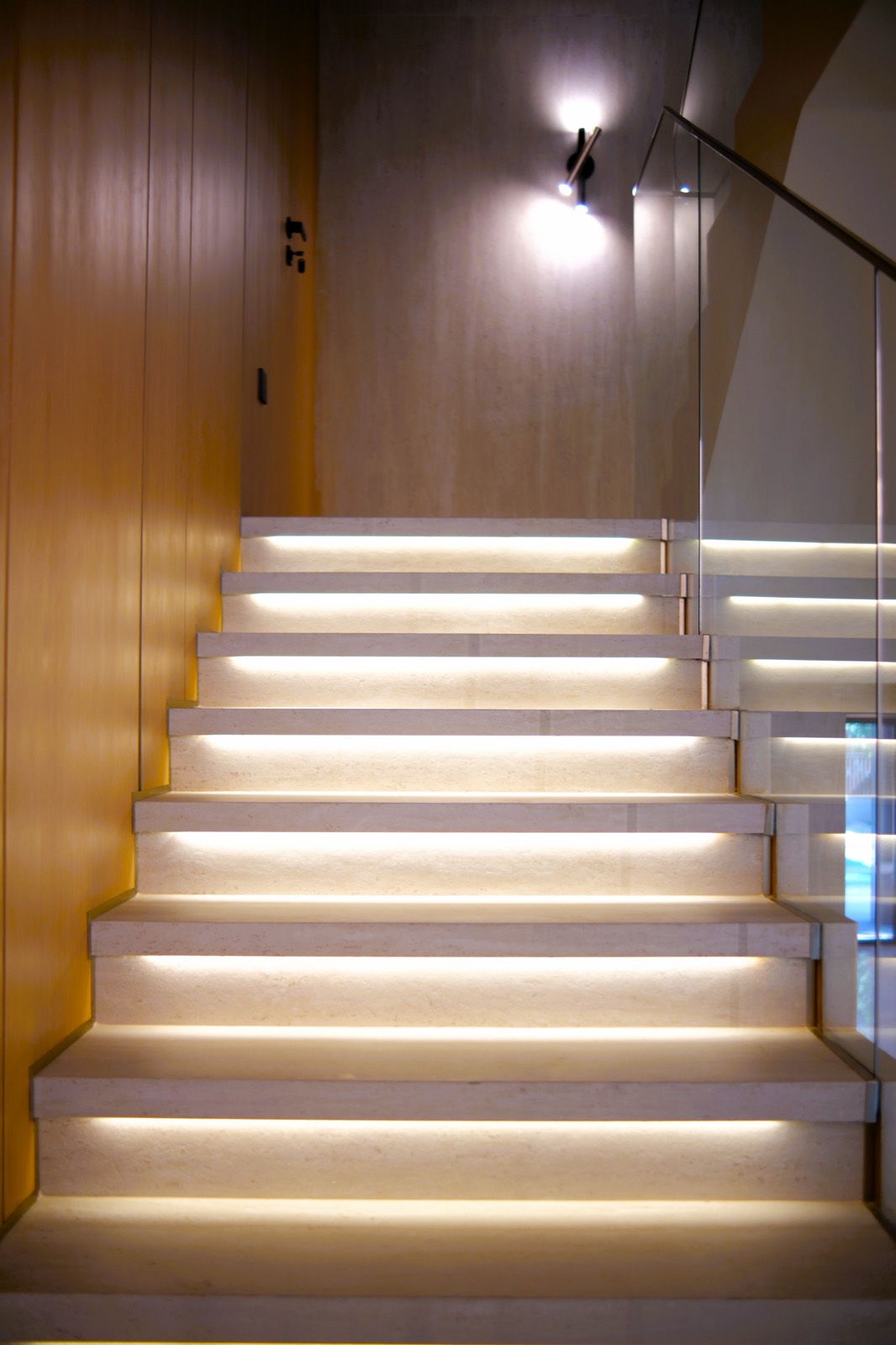 LED-lit stone staircase with oak panelling and glass balustrade