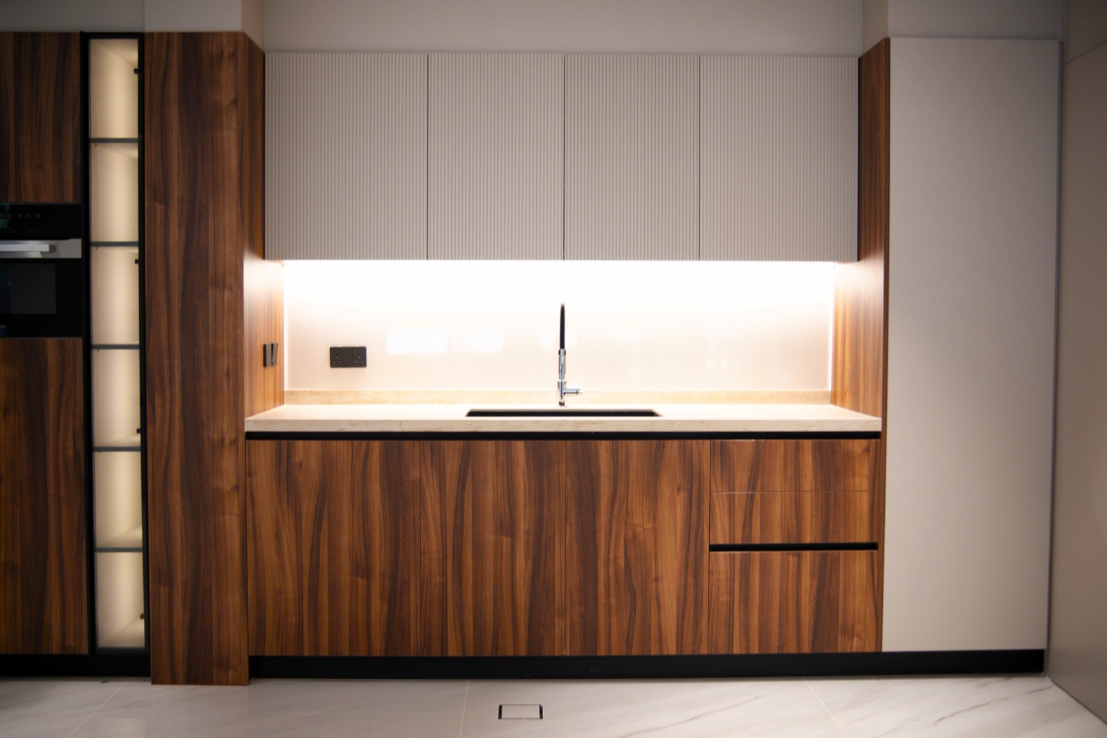 Bespoke walnut kitchen with fluted cabinetry and integrated under-cabinet lighting